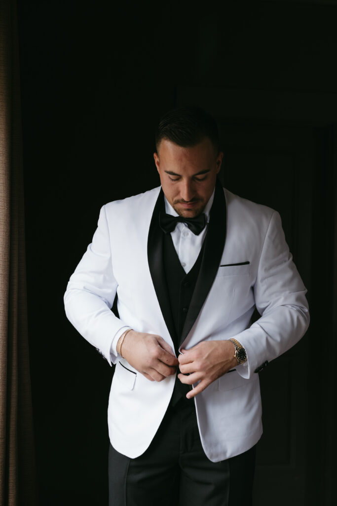 The groom wore a white suit at this colorful luxury wedding at Foxhall Resort. | Megan Kuhn Photography