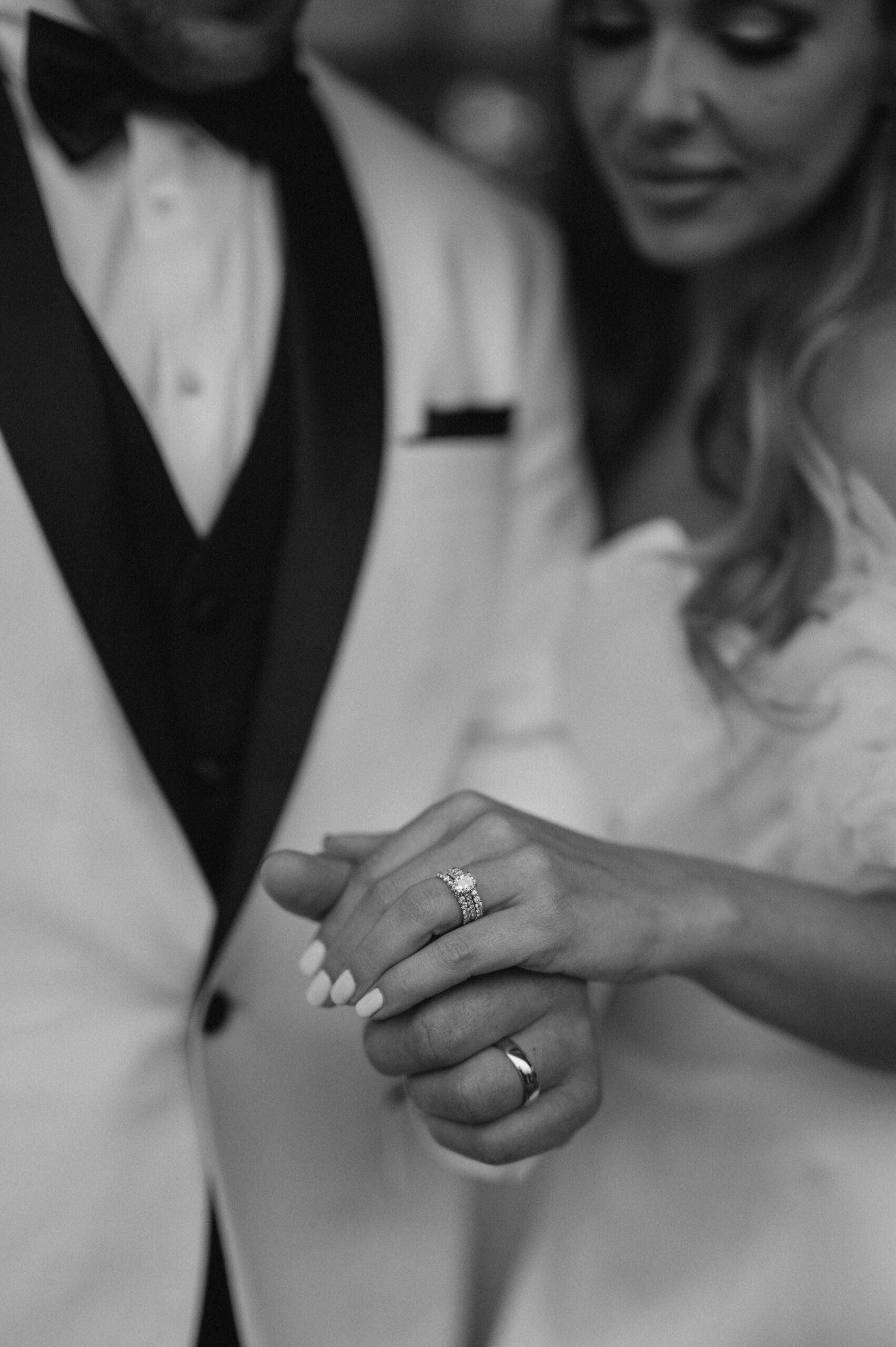 Black and white wedding couple portraits looking at rings at Foxhall Resort | Megan Kuhn Photography