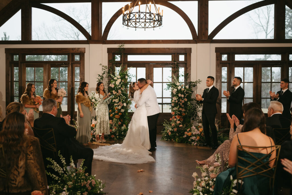 Luxury wedding at Foxhall Resort with a broken floral arch and candles. | Megan Kuhn Photography