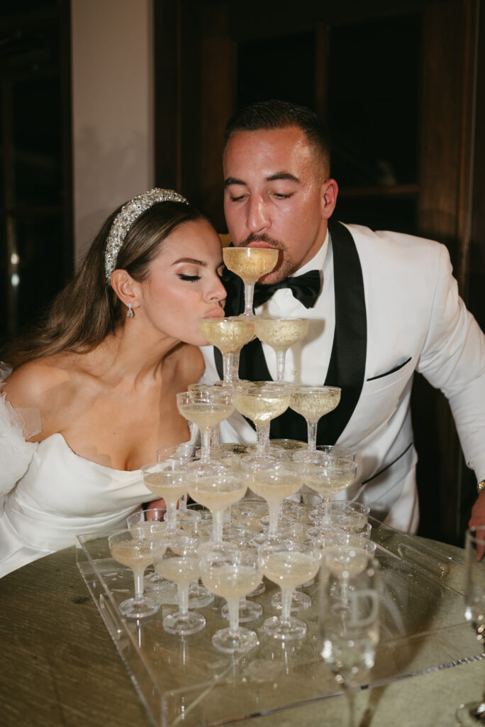 Wedding couple drinking out of champagne tower | Megan Kuhn Photography